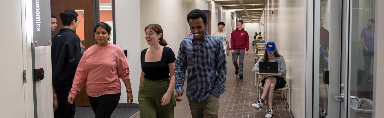 Students walking down hallway to MQE